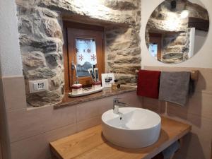 蓬圣马丁Bed & Breakfast La Crotta的浴室设有白色水槽和镜子
