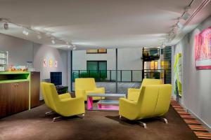 布鲁塞尔布鲁塞尔舒曼雅乐轩酒店的一间设有黄色椅子和桌子的等候室