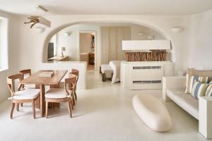 伊亚圣托里尼神秘豪华酒店的白色的客厅配有桌子和沙发