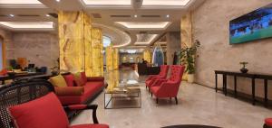 巴士拉Move npic Zenat al Hayat Hotel的大堂配有沙发、椅子和电视。