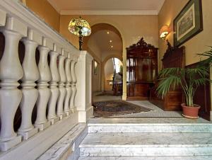 罗马西尔维酒店的一条有白色柱子的走廊和一条有盆栽植物的楼梯