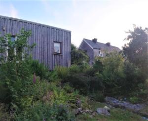 斯莱戈Innisfreedom cabin的一座建筑和一座带花园的房子