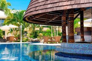 阿皮亚萨摩亚阿吉格雷简易别墅喜来登酒店的一个带椅子和遮阳伞的度假村游泳池