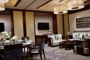 武汉武汉光明万丽酒店的酒店客房设有餐桌和客厅。
