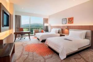 普特拉贾亚普特拉贾亚艾美度假酒店的酒店客房设有两张床、一张桌子和一台电视。