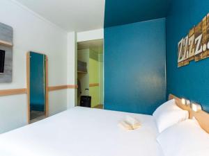 庞坦巴黎庞坦门宜必思快捷酒店的一间卧室设有一张蓝色墙壁的大床