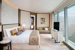 长沙长沙梅溪湖金茂豪华精选酒店的卧室配有一张白色大床和电视。