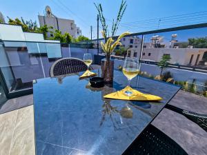 阿依纳帕Giorgis Luxury Apartments的阳台上的桌子和两杯葡萄酒