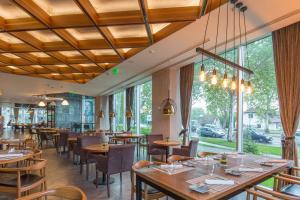 诺维萨德Sheraton Novi Sad的餐厅设有木制天花板和桌椅