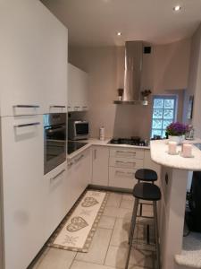 博尔戈马内罗Blue House的厨房配有白色橱柜、柜台和凳子