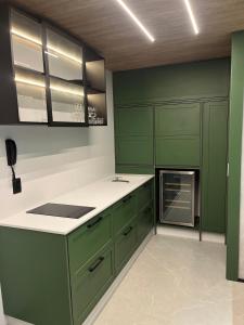 克里西玛Hub Home - Vista Incrível的厨房配有绿色橱柜和白色台面