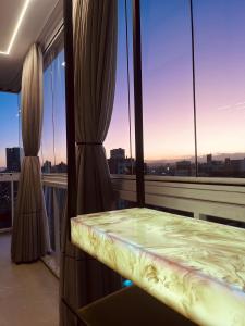 克里西玛Hub Home - Vista Incrível的窗户客房内的一个阳台,配有一张床