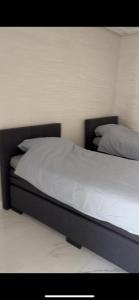 纳祖尔Appartement Nador Jadid的一间卧室配有带白色床单和枕头的床。
