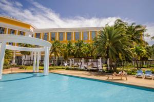 La Playa玛格丽塔岛赫斯珀里亚酒店的躺在酒店游泳池旁的长凳上的人