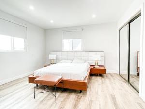 洛杉矶Stylish 4BR Townhouse in Mid City - CR2-C2的一间白色卧室,配有床和2个窗户