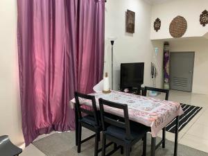 Bandar Puncak AlamRosevilla Homestay - 3R2B Fully Aircond WiFi的一间带桌子和粉红色窗帘的用餐室