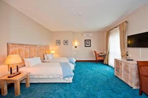 鲸湾港鹈鹕湾普罗提酒店 的酒店客房设有两张床和一台平面电视。