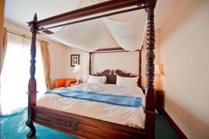 鲸湾港鹈鹕湾普罗提酒店 的一间卧室配有一张四柱床和天蓬