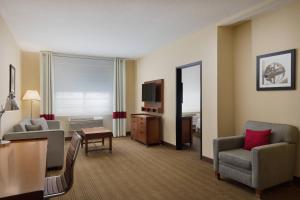 波特兰波特兰东部福朋喜来登酒店的酒店客房设有沙发、椅子和电视。