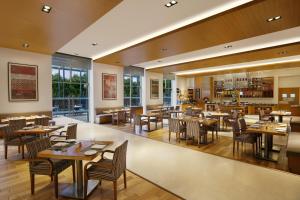 浦那Four Points by Sheraton Hotel and Serviced Apartments Pune的一间带桌椅的用餐室和一间餐厅