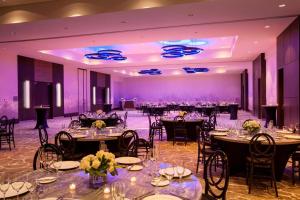 密尔沃基密尔沃基威斯汀酒店的宴会厅配有桌椅和紫色照明