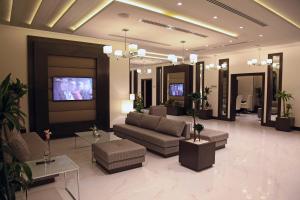 麦地那Marriott Executive Apartments Madinah的带沙发和桌子的客厅以及电视。