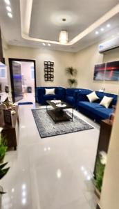 艾卜哈الجوهرة الزرقاء بجوار فعاليات سما أبها的客厅配有蓝色的沙发和桌子