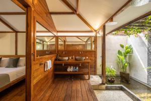吉利特拉旺安Gili Teak Beach Front Resort的一间带一张床和两个盥洗盆的浴室