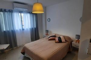 洛马斯-德萨莫拉Departamento moderno en Las Lomitas的一间卧室配有一张带灯具的大床