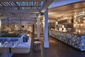 日惹日惹万豪酒店的一间设有蓝色沙发的餐厅和一间酒吧