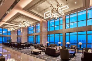 滁州滁州港汇喜来登酒店的大型大堂设有桌椅和大窗户
