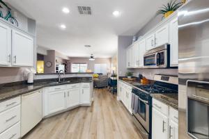 Sun LakesRiviera Retreat的厨房配有白色橱柜和不锈钢用具