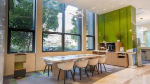南通南通星湖智选假日酒店的厨房设有绿色的墙壁和桌椅