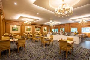 曼谷阿里斯顿酒店曼谷的一间带桌椅的餐厅和一间酒吧