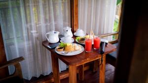 德格拉朗Tirta Jenar Villas的一张桌子,上面有一盘食物和饮料