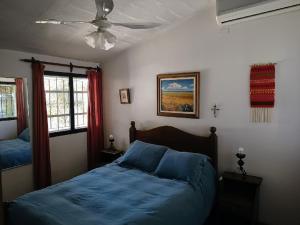 圣胡安Complejo Los Aromos, San Juan, AR的一间卧室配有两张床和吊扇