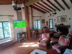 圣胡安Complejo Los Aromos, San Juan, AR的客厅配有电视、沙发和椅子
