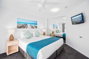 黄金海岸Sovereign on the Gold Coast的一间带大床和电视的卧室