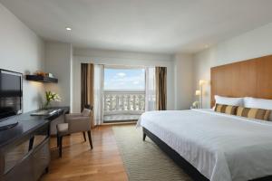 曼谷Tower Club at lebua的配有一张床、一张书桌和一扇窗户的酒店客房