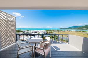 埃尔利海滩Ocean Views at Whitsunday Terraces Resort的阳台配有桌椅,享有海滩美景。