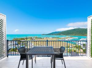 埃尔利海滩Ocean Views at Whitsunday Terraces Resort的海景阳台上的桌椅