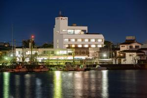 Itako新野米酒店的一座大型建筑,晚上在水中装船