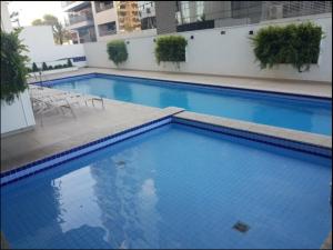 巴鲁埃里Conjunto Estudio e Duplex Selenita的大楼里的一个大型蓝色游泳池
