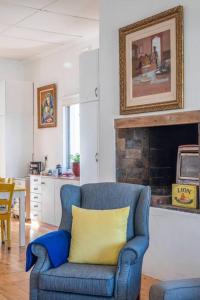 开普敦Vintage Charm in Tamboerskloof的客厅里一张带黄色枕头的蓝色椅子