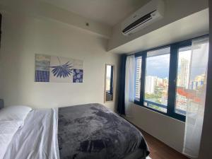 马尼拉Air Residences Makati - fully furnished condo with skyline views!的一间卧室设有一张床和一个大窗户