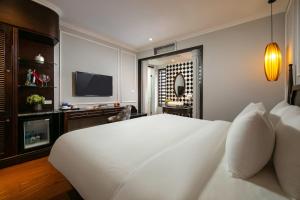 河内Salute Premium Hotel & Spa的卧室配有一张白色大床和电视。