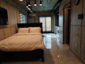 西归浦市Soo Stay的一间带一张大床的卧室,位于带窗户的房间内