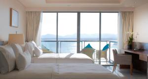 普吉镇The Westin Siray Bay Resort & Spa, Phuket的酒店客房设有两张床、一张书桌和一个窗户。