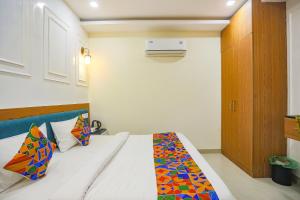 阿拉哈巴德FabHotel Cosmos的一间卧室,床上有五颜六色的被子