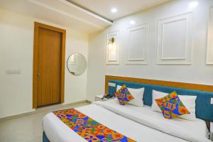 阿拉哈巴德FabHotel Cosmos的一间卧室配有一张大床和蓝色床头板